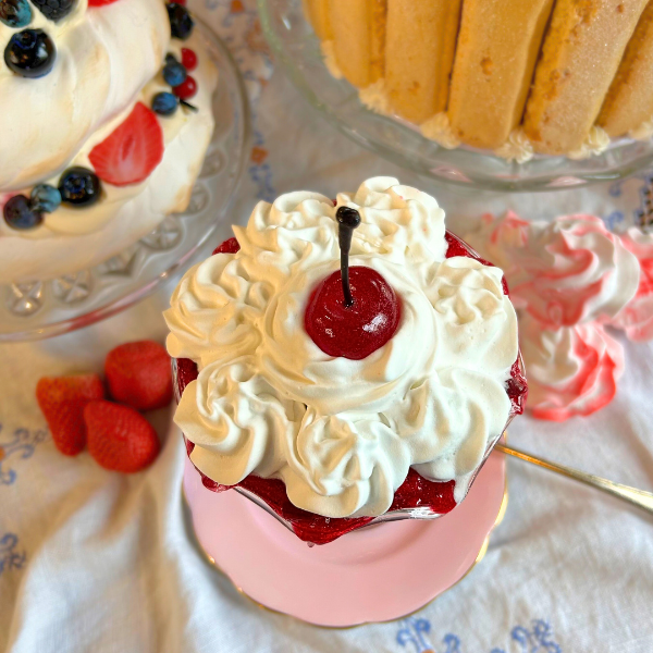 Layered cream and strawberry sauce dessert with cherry
