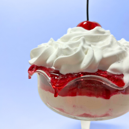 Layered cream and strawberry sauce dessert with cherry