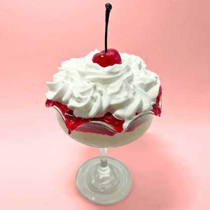Layered cream and strawberry sauce dessert with cherry