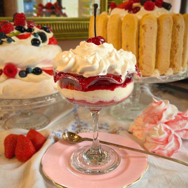 Layered cream and strawberry sauce dessert with cherry