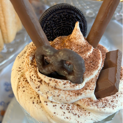 Dessert with whipped cream, chocolate, and an Oreo cookie on a decorative plate.