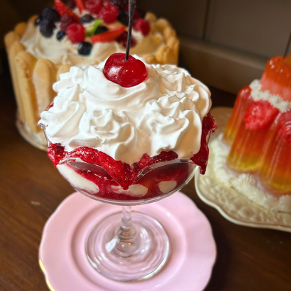 Layered cream and strawberry sauce dessert with cherry